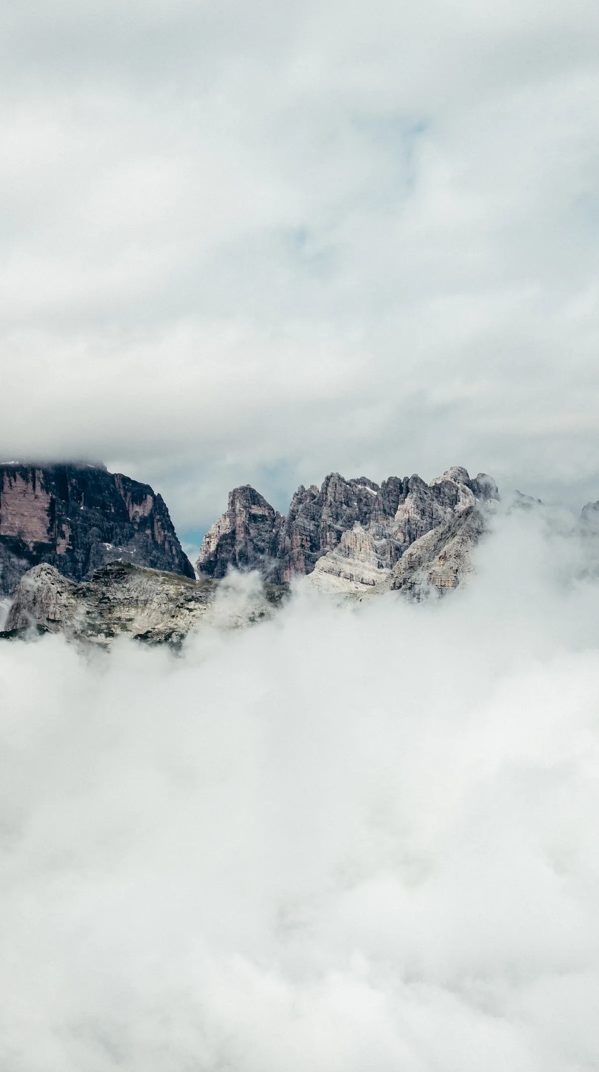 Rugged alpine mountain peaks rising above a sea of white clouds